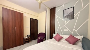 Un dormitorio con cama, armario, silla y ventilador de techo.