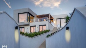 Een modern meerlaags huis met een trap die naar een balkon leidt.