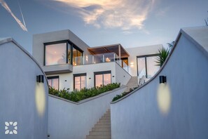 Ein modernes mehrgeschossiges Haus mit einer Treppe, die zu einem Balkon führt.