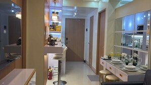 A modern kitchen with a central island, a dining area with a sofa, and a bar area with stools. - Ella’s Haven @ Shore 3 Residences • 2BR Walk to MOA • Minutes from NAIA (Pasay City)