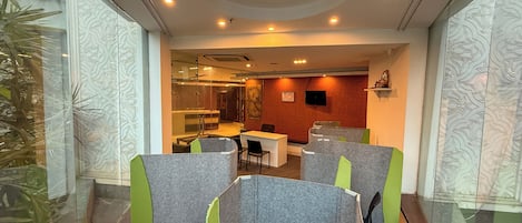 Un moderno spazio ufficio con cubili, una zona reception e un'area pranzo.