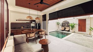 Una cocina moderna con comedor, piscina y zona de estar con vistas a la piscina.