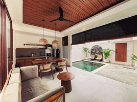 Una cocina moderna con comedor, piscina y zona de estar con vistas a la piscina.