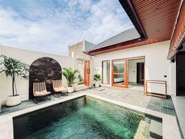 Una casa moderna con piscina, arco de piedra y puertas de madera.