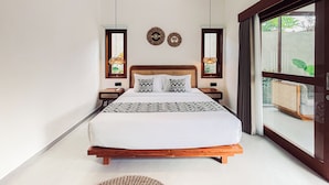 Un dormitorio con una cama de madera, dos mesitas de noche, un ventanal y vistas al verdor exterior.