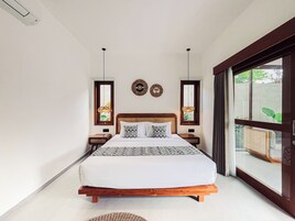 Un dormitorio con una cama de madera, dos mesitas de noche, un ventanal y vistas al verdor exterior.