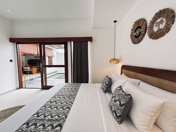 A bedroom with a large bed, a view to the outside, and a ceiling light. - DeDarva Villa Ubud (Ubud)