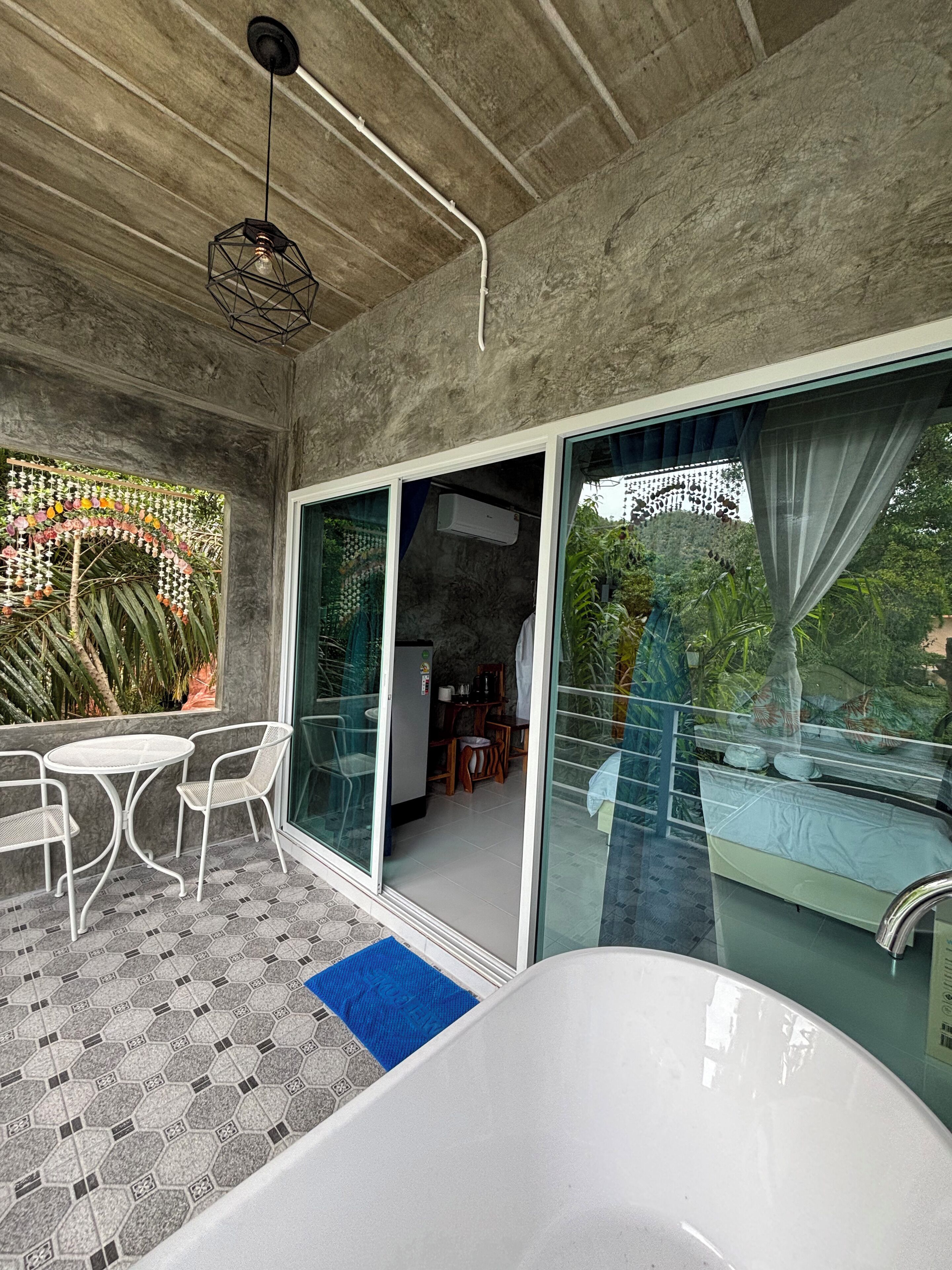 A modern bathroom with a large bathtub, a glass-enclosed shower area, and a view of the outdoors.