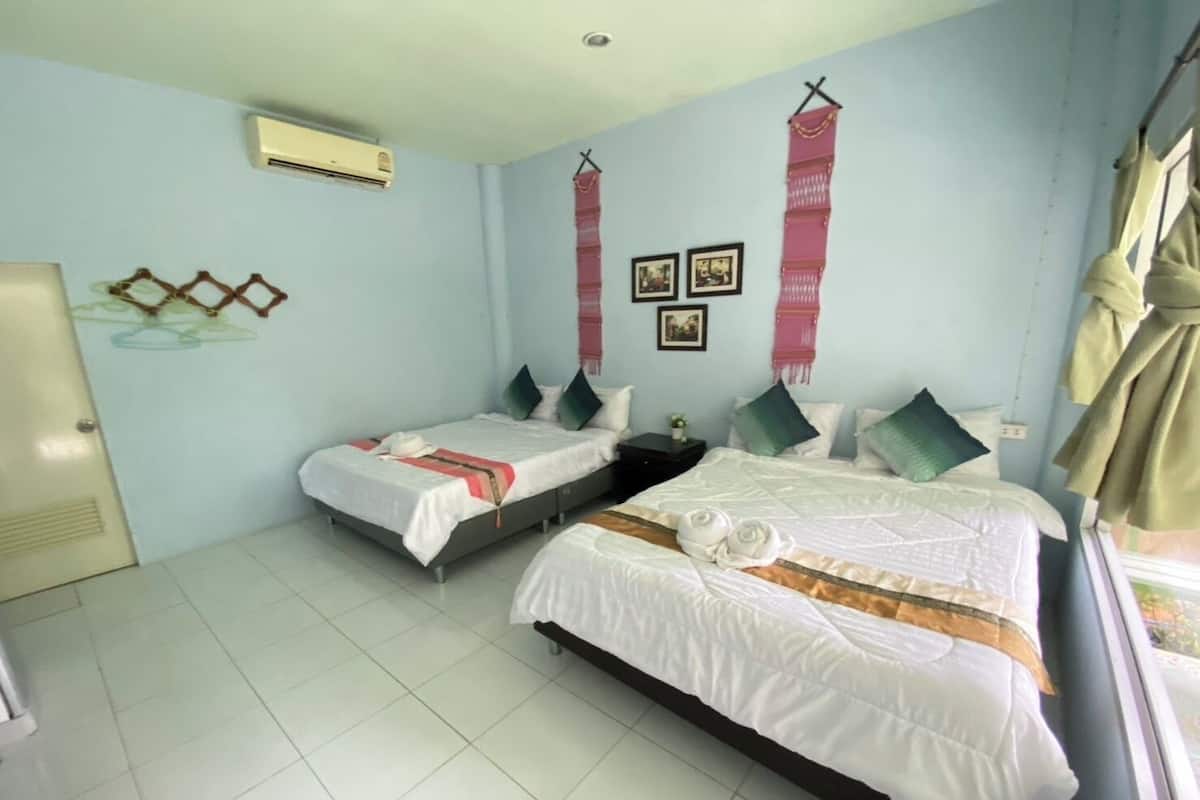 Habitación de hotel con dos camas, un armario, un escritorio y una ventana con cortinas.