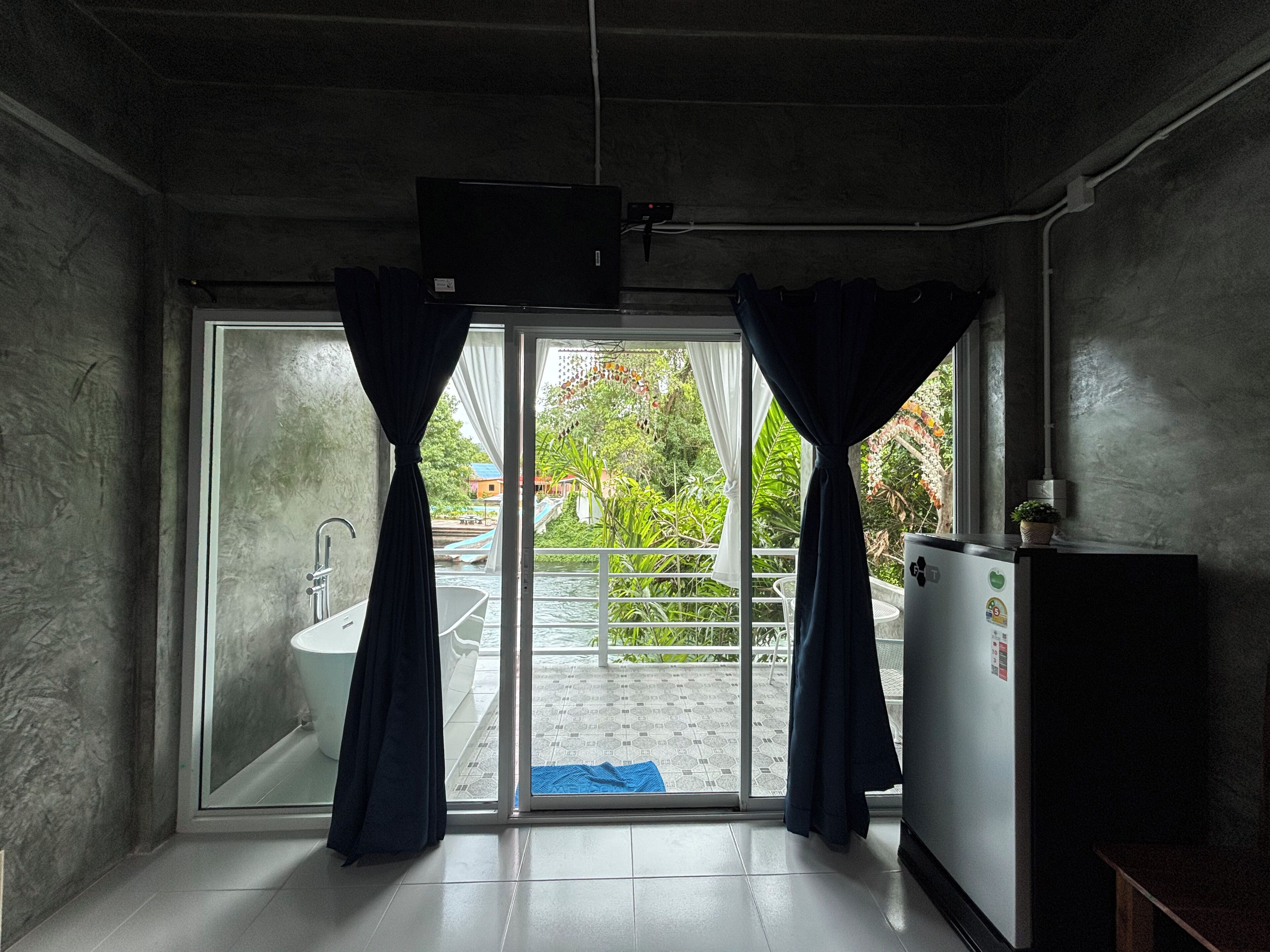 Baño con bañera, inodoro y lavamanos. Posee una puerta corrediza de vidrio que da a un área exterior con balcón.