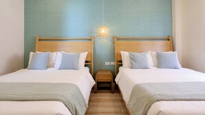 A hotel room with two beds, a small wooden stool, and a wall-mounted light fixture. - Alesea Baroro: Private Beachfront Villa - Pool, Jacuzzi (Bacnotan)