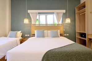 Habitación de hotel con una cama grande, dos mesitas de noche, un armario y una ventana con cortinas.