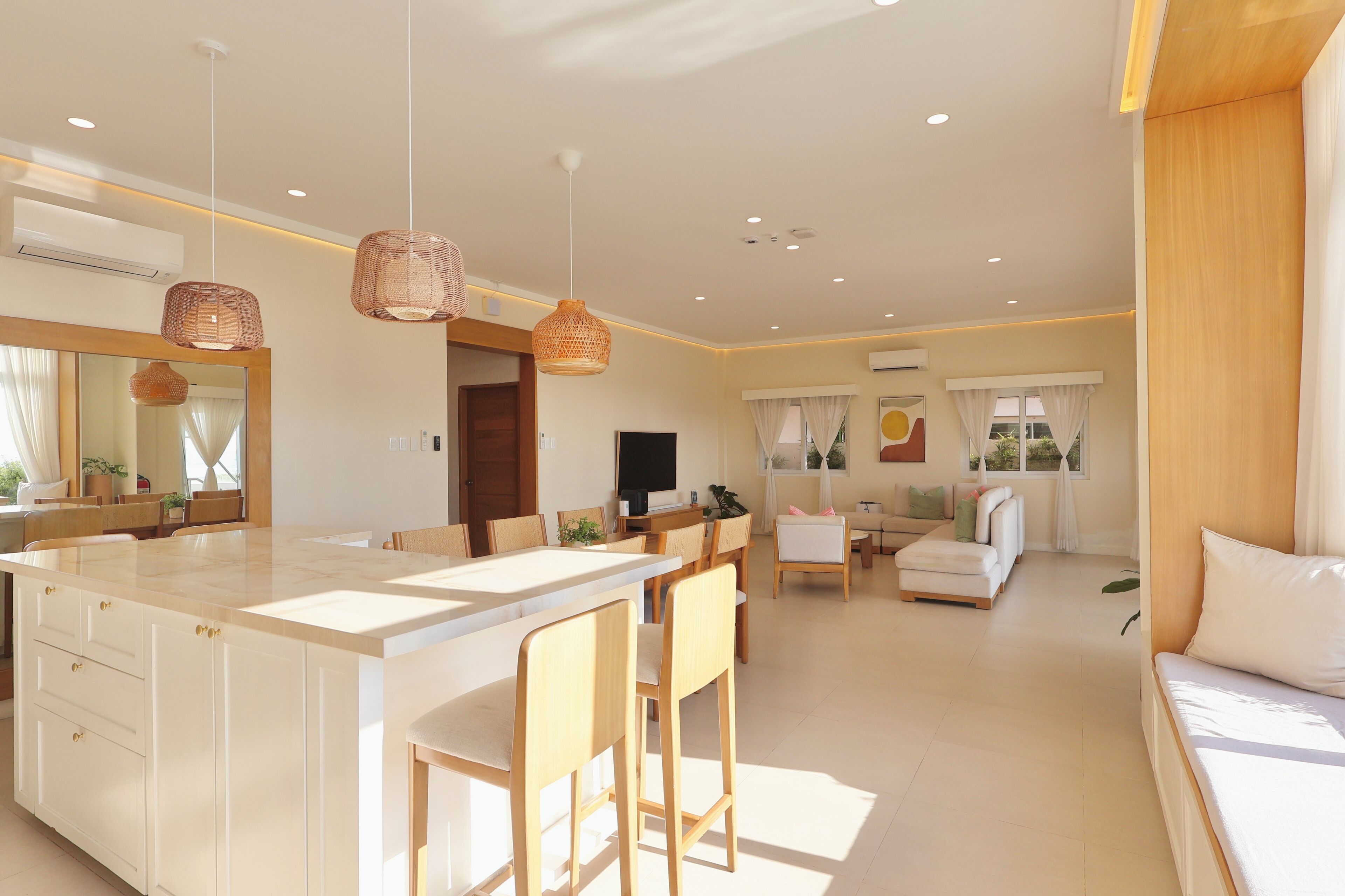 A spacious living area with a central island, a dining area, and a seating area with a sofa and chairs.