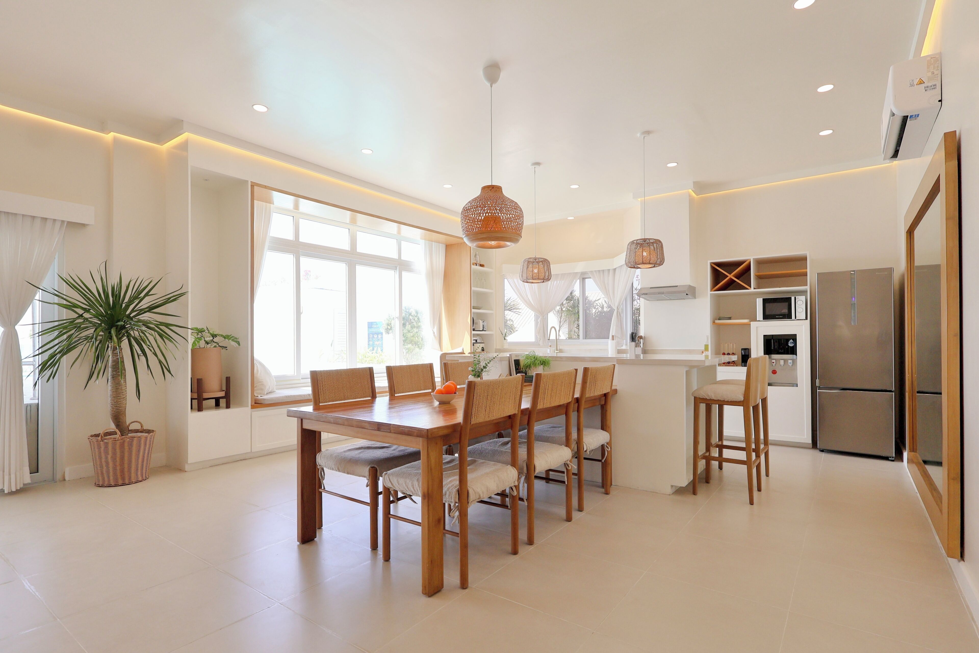 Una cocina moderna con comedor, ventanas amplias y electrodomésticos integrados.