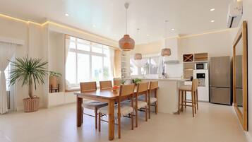 Una cocina moderna con comedor, ventanas amplias y electrodomésticos integrados.