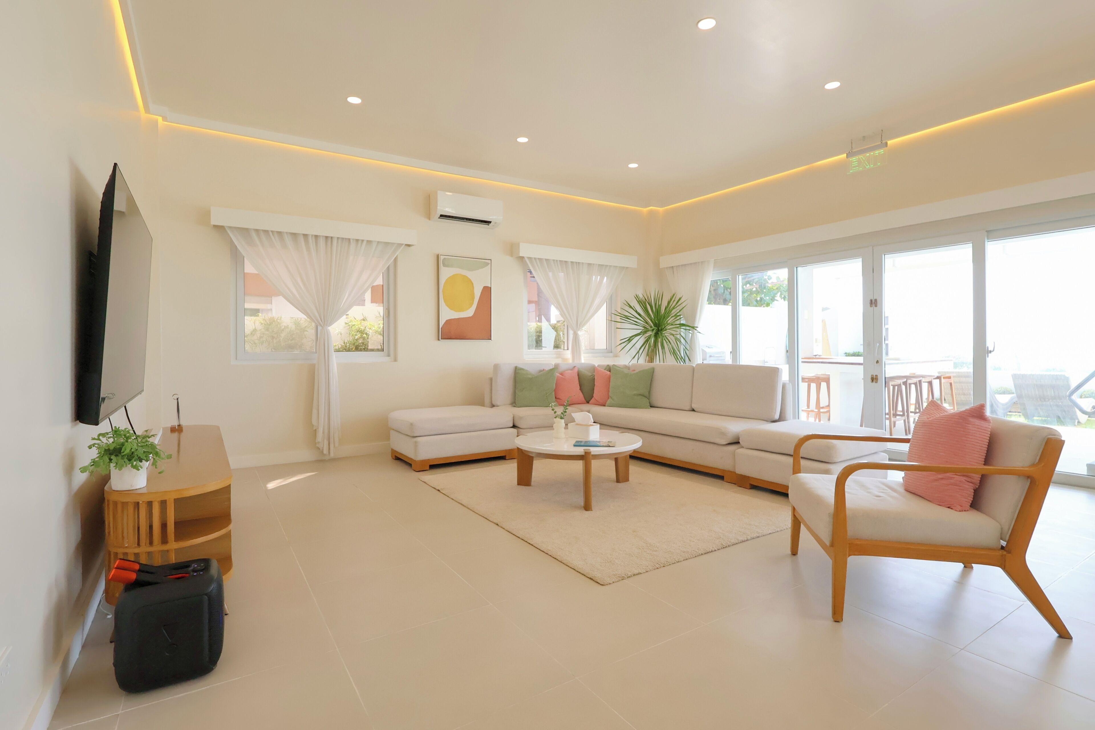 Una sala de estar moderna con un sofá, un sillón, una mesa de centro y una mesita auxiliar con una planta.