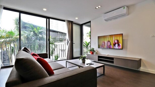 Una sala de estar moderna con un sofá, una mesa de centro y un televisor montado en la pared.