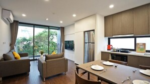 Una cocina moderna con comedor, ventanas amplias y un refrigerador.