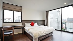 Una habitación de hotel moderna con una cama grande, un escritorio y vistas a la ciudad por la ventana.