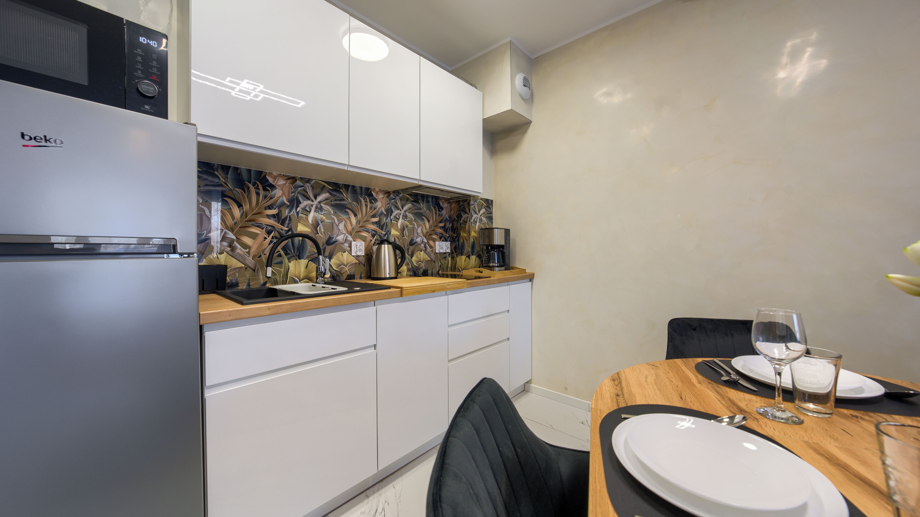 A compact kitchen with a refrigerator, microwave, and a coffee maker.