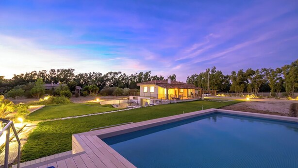 A swimming pool with a wooden deck, a house with a patio, and a well-maintained lawn. - Sunset Villa - Entire Structure (Alghero)