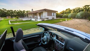 The interior of a car with a view of a house and a well-maintained lawn. - Sunset Villa - Entire Structure (Alghero)