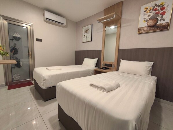 Quarto de hotel com duas camas, banheiro e chuveiro.