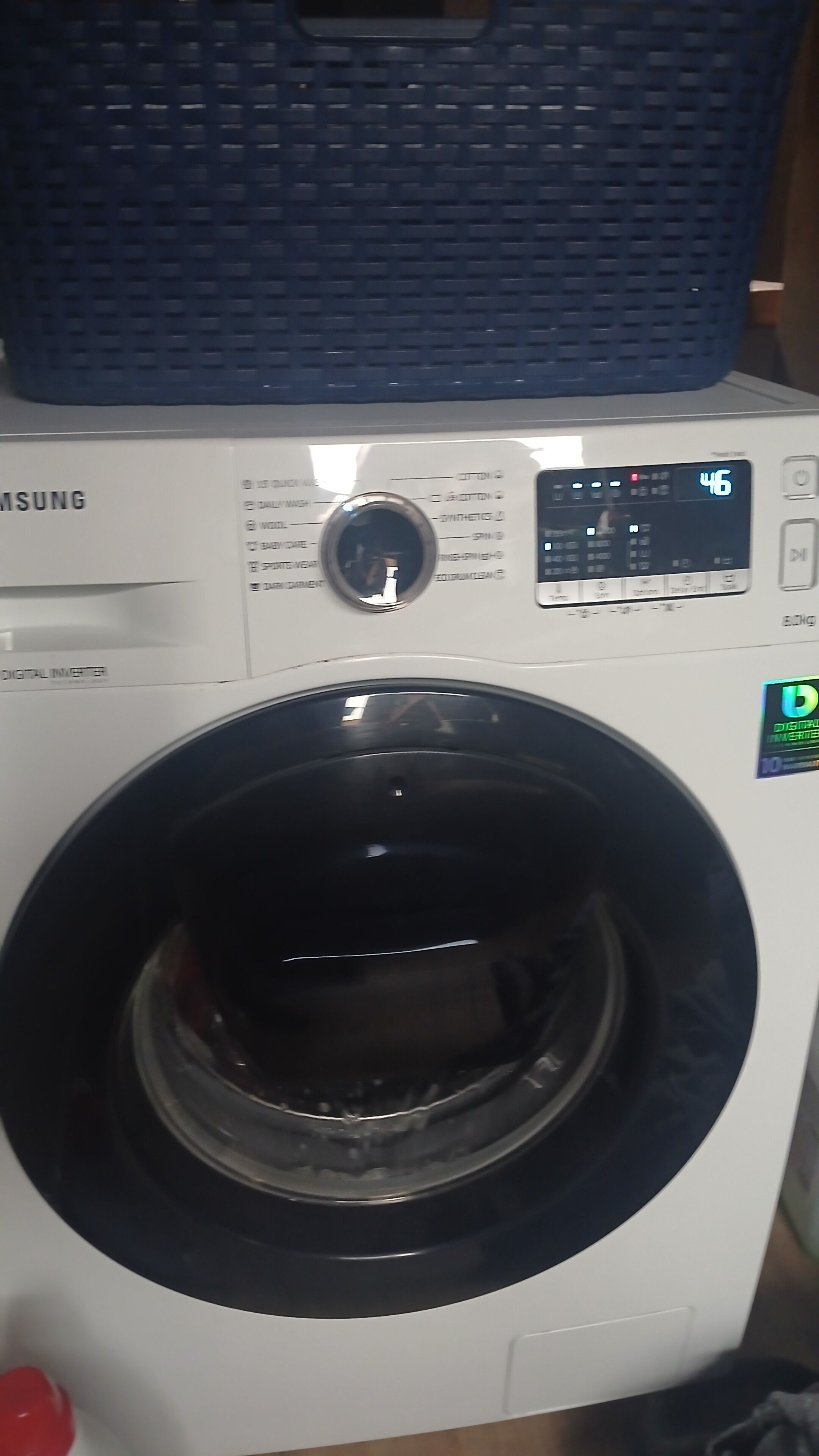 Una lavadora Samsung con tecnología digital inverter, con un panel de control que muestra diversas opciones y una pantalla digital.