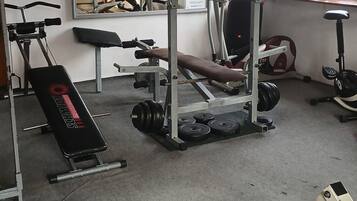 Un gimnasio con equipo de ejercicio, un espejo grande y una ventana que ofrece vistas al exterior.