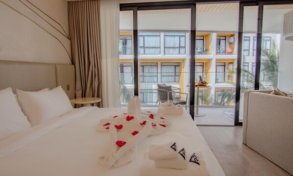 Une chambre d’hôtel avec un lit, une petite table et un balcon donnant sur un immeuble.