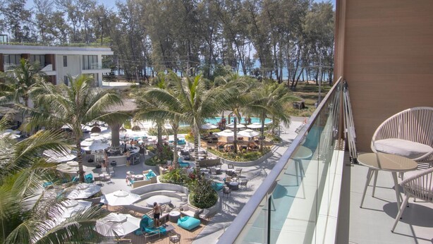 Un resort con area piscina, lettini e palme.
