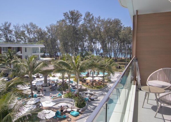 Ein Resort mit Poolbereich, Liegestühlen und Palmen.