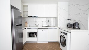 A modern kitchen with white cabinetry, a built-in dishwasher, a microwave, a toaster, and a coffee maker. - 189/222 3BR Beachfront Luxe Pool Access (Choeng Thale)