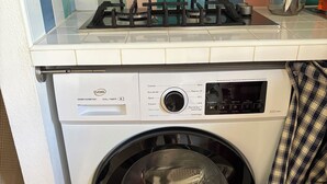 Een voorlader wasmachine met een digitaal display, een bedieningspaneel en een deur.
