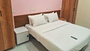 Une chambre à coucher avec un lit, des tables de chevet et une armoire en bois.