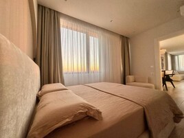 A hotel room with a large bed, a chair, and a desk.