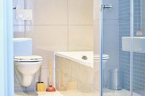 A modern bathroom with a toilet, bidet, and glass shower enclosure. - City Apartments at Freedom Plaza (Windhoek)