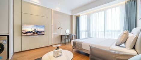 Ein modernes Hotelzimmer mit einem Bett, einem Schreibtisch, einem Stuhl, einem an der Wand befestigten Fernseher und einem Fenster mit Vorhängen.