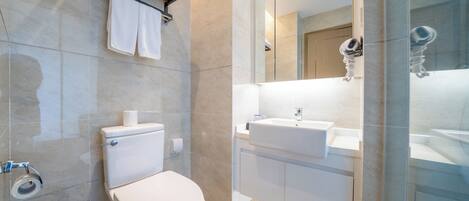 A modern bathroom with a toilet, sink, and shower area.