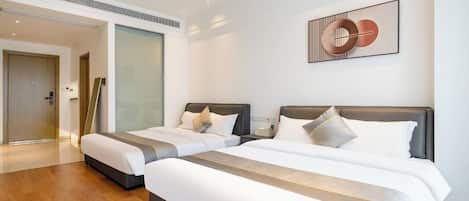 Quarto de hotel com duas camas, design moderno e uma janela grande.