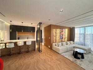A modern living space with a kitchen, a dining area, and a seating area with a sofa and a coffee table. - City Centre Penthouse  (Tirana)