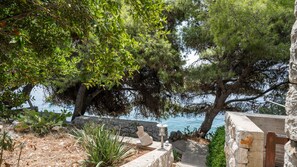 A coastal landscape with a stone wall, a stone bench, and a view of the sea. - Waterfront house Kata by Villas Guide (Smokvica)