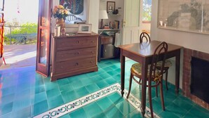 Uma área de refeições com mesa e cadeiras de madeira, cozinha ao fundo e varanda com vista.