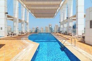 A rooftop swimming pool with a clear view of the city skyline. - Modern 2BR Marina Apt | Canal View | Pool & Sauna (Dubai)