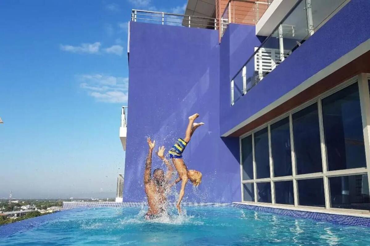 A swimming pool with a blue wall and a large window.
