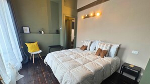 Une chambre à coucher avec un grand lit, une chaise, une table de chevet et une étagère ornée d’objets décoratifs.