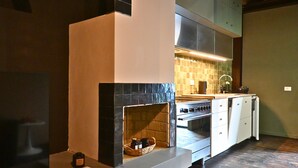 Une cuisine moderne équipée d’une cuisinière, d’un four et d’un four à micro-ondes intégrés. On peut voir un panier rempli de bouteilles sur le comptoir.