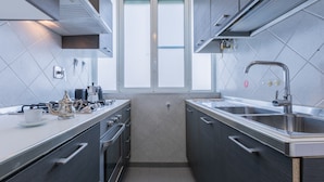 A modern kitchen with stainless steel appliances, a window, and a sink. - Bright and Modern Apartment by Wonderful Italy (Turin)