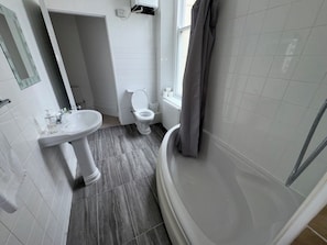 Un baño con lavamanos, inodoro y bañera.