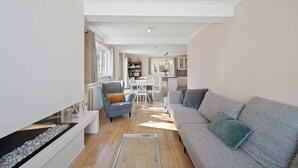 Un salon moderne avec un canapé, un fauteuil et une table basse en verre.